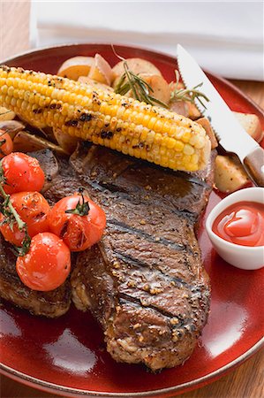 Grilled steak, corn on the cob, cherry tomatoes, potatoes, ketchup Fotografie stock - Premium Royalty-Free, Codice: 659-03526967