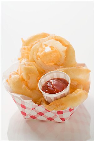 simsearch:659-01847898,k - Rondelles d'oignon frites avec du ketchup dans le contenant en carton Photographie de stock - Premium Libres de Droits, Code: 659-03526998