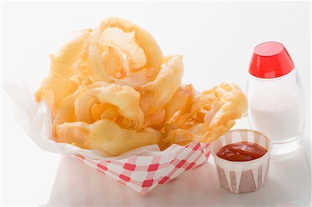 simsearch:659-06188151,k - Rondelles d'oignon frites dans un contenant en carton, ketchup, sel Photographie de stock - Premium Libres de Droits, Code: 659-03526999
