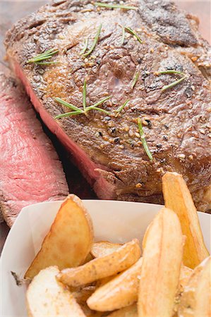 rare - Sirloin steak with potato wedges (close-up) Foto de stock - Sin royalties Premium, Código: 659-03527006