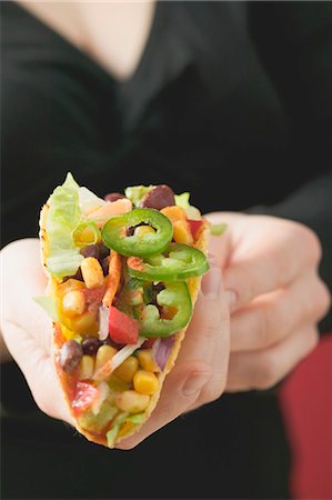 simsearch:659-03527105,k - Woman holding vegetable taco Foto de stock - Royalty Free Premium, Número: 659-03527093