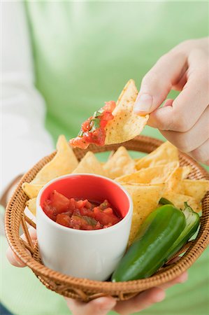 salsa picante - Woman holding basket of nachos with salsa and chilli Foto de stock - Sin royalties Premium, Código: 659-03527100