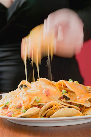 simsearch:659-03527105,k - Hand taking tortilla chip with melted cheese from plate Foto de stock - Royalty Free Premium, Número: 659-03527110