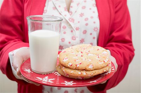 Woman holding Christmas cookies and glass of milk on plate Stock Photo - Premium Royalty-Free, Code: 659-03527232
