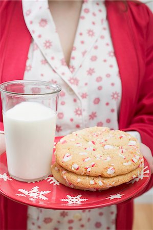 simsearch:659-03528144,k - Femme tenant le verre de lait et de biscuits de Noël sur la plaque Photographie de stock - Premium Libres de Droits, Code: 659-03527233