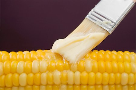 Brushing corn on the cob with butter Stock Photo - Premium Royalty-Free, Code: 659-03527293