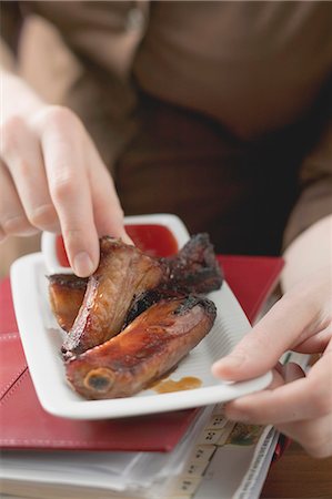 food delivery women - Woman eating glazed pork ribs in office Stock Photo - Premium Royalty-Free, Code: 659-03527309