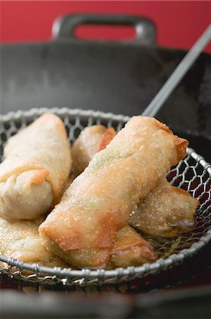 spring roll - Taking deep-fried spring rolls out of wok Stock Photo - Premium Royalty-Free, Code: 659-03527328