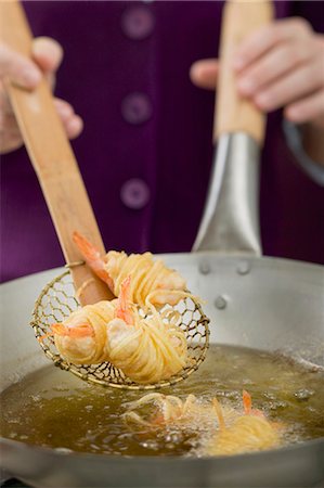 frying - Deep-frying noodle-wrapped prawns in wok Stock Photo - Premium Royalty-Free, Code: 659-03527321