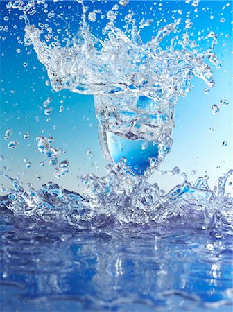 Blue water splashing out of glass Foto de stock - Sin royalties Premium, Código: 659-03527341