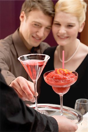 daiquiri - Waiter serving two drinks to romantic couple Fotografie stock - Premium Royalty-Free, Codice: 659-03527380