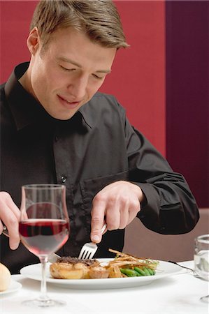 Man eating steak in restaurant Stock Photo - Premium Royalty-Free, Code: 659-03527390