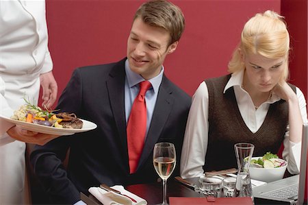 Waiter serving lunch to business people Stock Photo - Premium Royalty-Free, Code: 659-03527417
