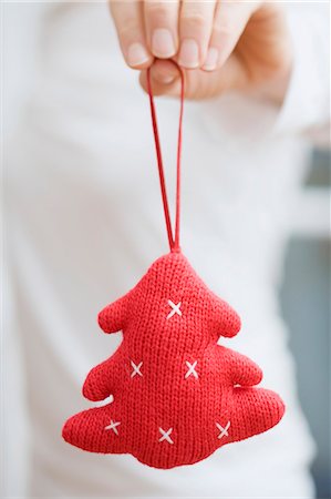 people decorate christmas tree - Hand holding knitted Christmas tree ornament Stock Photo - Premium Royalty-Free, Code: 659-03527487