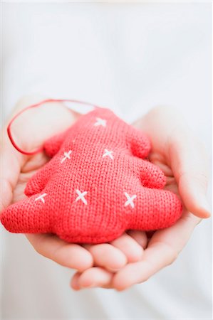 simsearch:659-03529405,k - Hands holding knitted Christmas tree ornament Fotografie stock - Premium Royalty-Free, Codice: 659-03527488