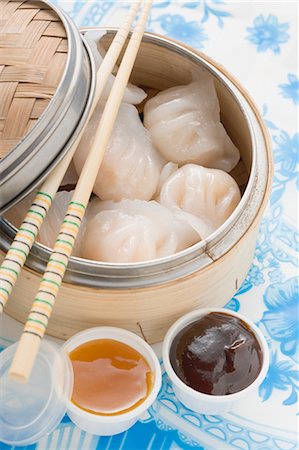 Dim sum in bamboo steamer, two sauces beside it (Asia) Stock Photo - Premium Royalty-Free, Code: 659-03527638