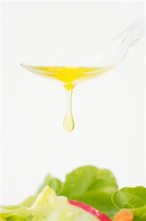 Olive oil dripping from a spoon onto salad Stock Photo - Premium Royalty-Free, Code: 659-03527765