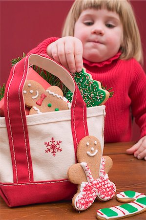Small girl taking Christmas biscuit out of bag Stock Photo - Premium Royalty-Free, Code: 659-03527861