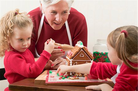 sweet lady cooking - Small girls and grandmother decorating gingerbread house Stock Photo - Premium Royalty-Free, Code: 659-03528133