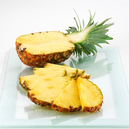 Half a pineapple and pineapple slices Foto de stock - Sin royalties Premium, Código: 659-03528263