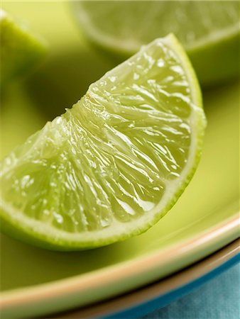 Lime wedge on plate (close-up) Stock Photo - Premium Royalty-Free, Code: 659-03528344