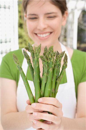 simsearch:659-03521659,k - Young woman holding fresh green asparagus Foto de stock - Sin royalties Premium, Código: 659-03528369