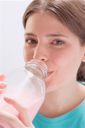 simsearch:659-03523361,k - Young woman drinking strawberry milk out of bottle Stock Photo - Premium Royalty-Free, Code: 659-03528379