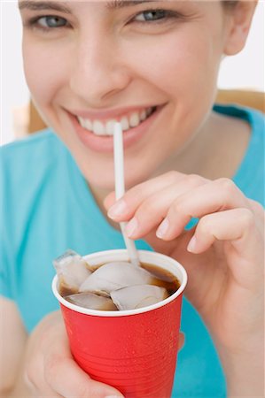 Young woman drinking cola through a straw Stock Photo - Premium Royalty-Free, Code: 659-03528383