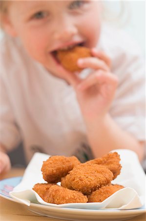 empanado - Little girl eating chicken nuggets Foto de stock - Sin royalties Premium, Código: 659-03528399