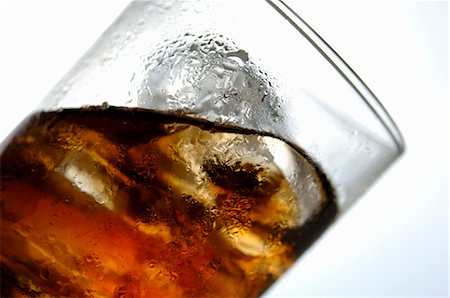 Cola with ice cubes in glass (tilted) Stock Photo - Premium Royalty-Free, Code: 659-03528470