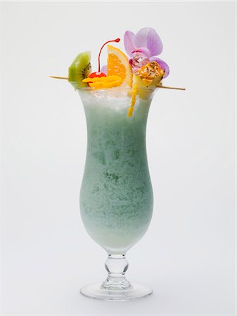 single cocktail - Long drink faite avec Curaçao bleu, avec une brochette de fruits Photographie de stock - Premium Libres de Droits, Code: 659-03528480