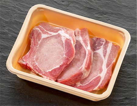 Three pork chops in plastic container Fotografie stock - Premium Royalty-Free, Codice: 659-03528737