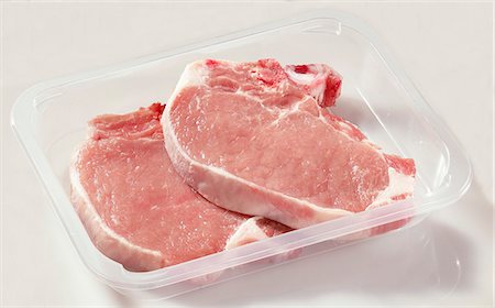 Two pork chops in plastic container Fotografie stock - Premium Royalty-Free, Codice: 659-03528738