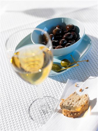 Olives, câpres, pain et verre de vin blanc Photographie de stock - Premium Libres de Droits, Code: 659-03528754