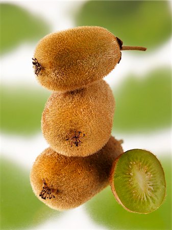 simsearch:659-01843575,k - Three whole kiwi fruits (stacked) beside half a kiwi fruit Stock Photo - Premium Royalty-Free, Code: 659-03528894