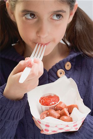 simsearch:659-03521588,k - Little girl eating frankfurters with ketchup Fotografie stock - Premium Royalty-Free, Codice: 659-03529070