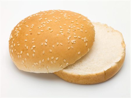 A hamburger bun with sesame seeds, split Stock Photo - Premium Royalty-Free, Code: 659-03529151