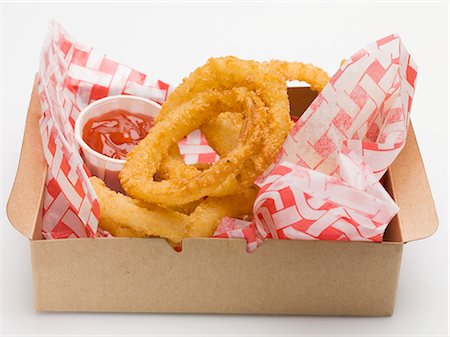 simsearch:659-01847898,k - Rondelles d'oignon frites avec du ketchup dans une boîte en carton Photographie de stock - Premium Libres de Droits, Code: 659-03529169