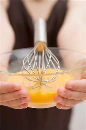 simsearch:659-03529414,k - Child holding bowl of egg yolks and whisk Fotografie stock - Premium Royalty-Free, Codice: 659-03529406