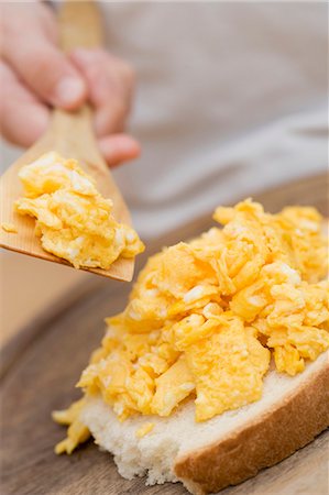 scrambled - Child spreading scrambled egg on bread Foto de stock - Sin royalties Premium, Código: 659-03529409