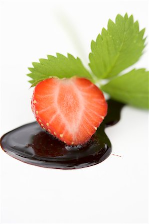 Half a strawberry with chocolate sauce and strawberry leaf Stock Photo - Premium Royalty-Free, Code: 659-03529433