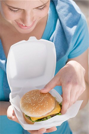 polystyrène - Young woman taking cheeseburger out of polystyrene box Foto de stock - Sin royalties Premium, Código: 659-03529476