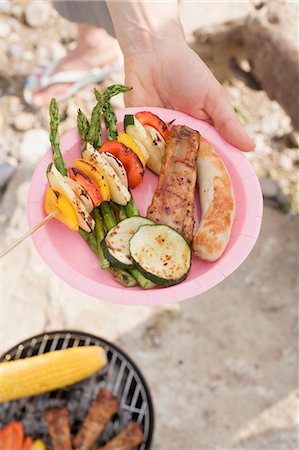 Hand holding plate of grilled food Stock Photo - Premium Royalty-Free, Code: 659-03529508