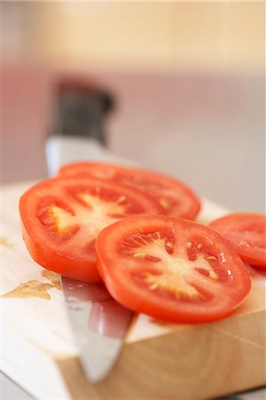 Tranches de tomate sur la planche à découper avec couteau Photographie de stock - Premium Libres de Droits, Code: 659-03529534