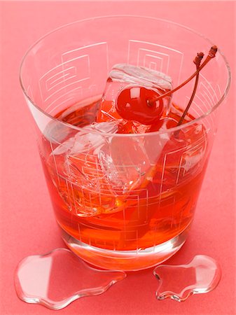 red cocktail - Manhattan with cocktail cherries and ice cubes Stock Photo - Premium Royalty-Free, Code: 659-03529595