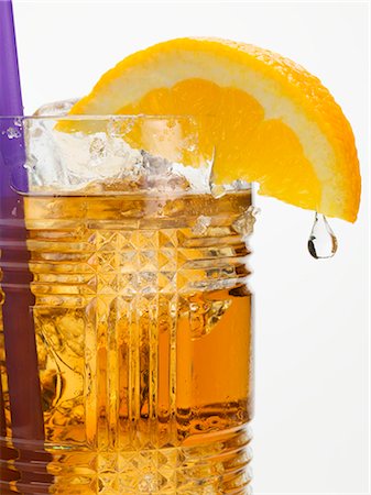 Rum drink with ice cubes and orange wedge with drip Stock Photo - Premium Royalty-Free, Code: 659-03529599