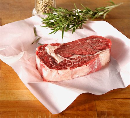 Raw rump steak on paper, rosemary, peppercorns Stock Photo - Premium Royalty-Free, Code: 659-03529709