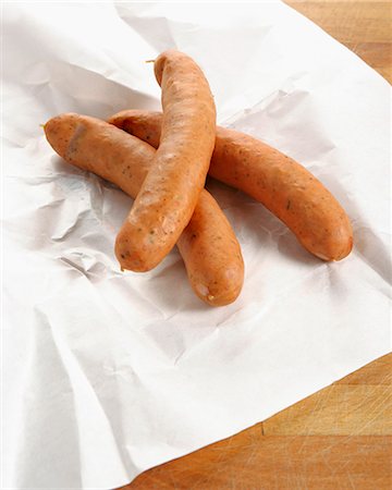 Three cheese-stuffed sausages on paper Stock Photo - Premium Royalty-Free, Code: 659-03529703