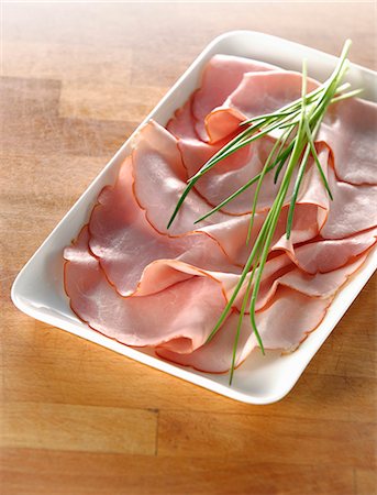 sliced ham - Plusieurs tranches de jambon bouilli et ciboulette fraîche Photographie de stock - Premium Libres de Droits, Code: 659-03529714