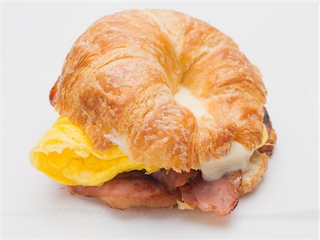simsearch:659-03529738,k - Croissant rempli de œufs brouillés, de bacon et de fromage Photographie de stock - Premium Libres de Droits, Code: 659-03529734